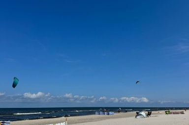 Szeroka ,piaszczysta plaża z miekkim, jasnym piaskiem i łagodnym wejsciu do morza